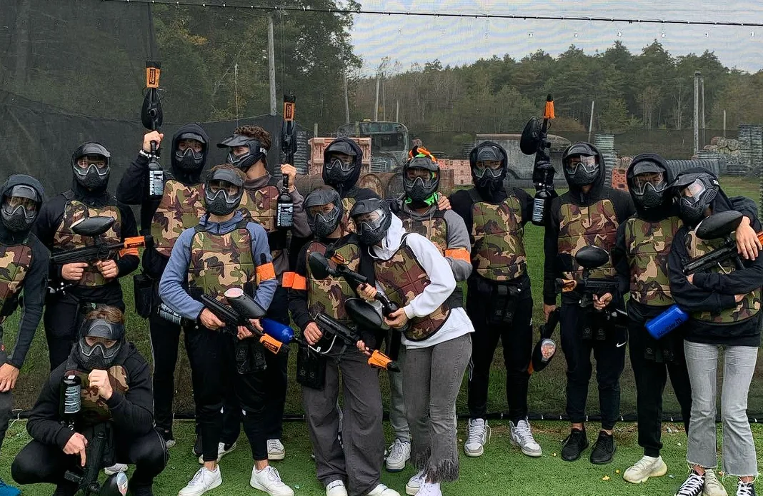 A group of young paintball players wearing protective masks and vests