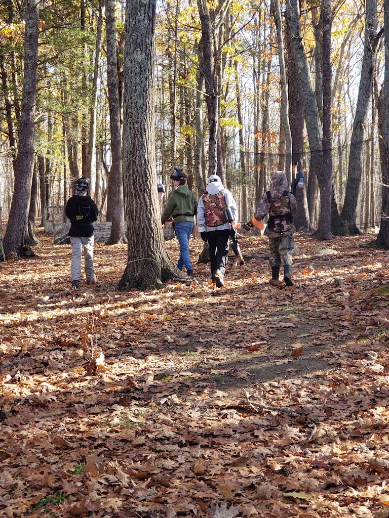 Birthday group in protective paintball gear walking through the Woods field
